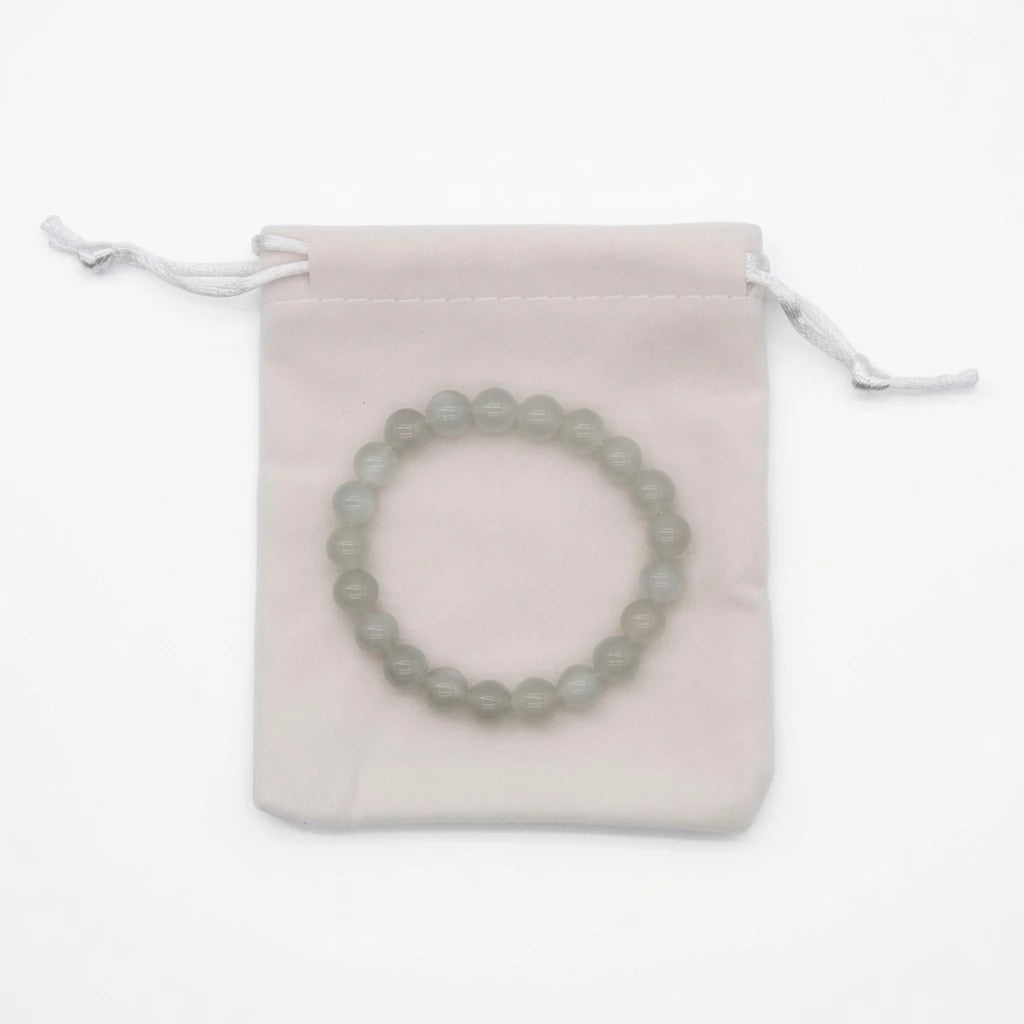 Natural moonstone beaded bracelet with translucent milky white 8mm round stones showing blue adularescence sheen, healing crystal jewelry for new beginnings on white background