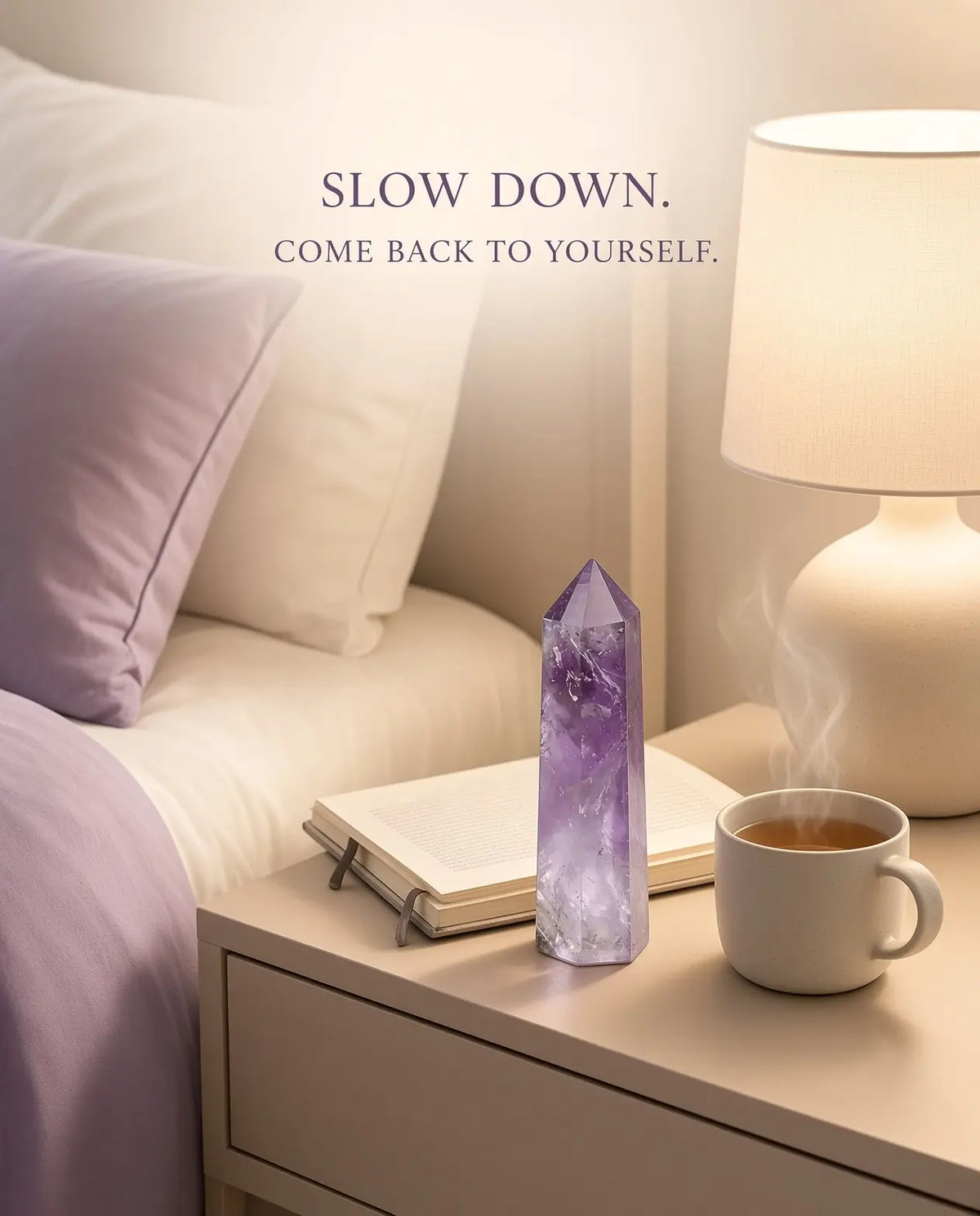 Obsidian crystal tower styled with tea, lamp and book in evening light