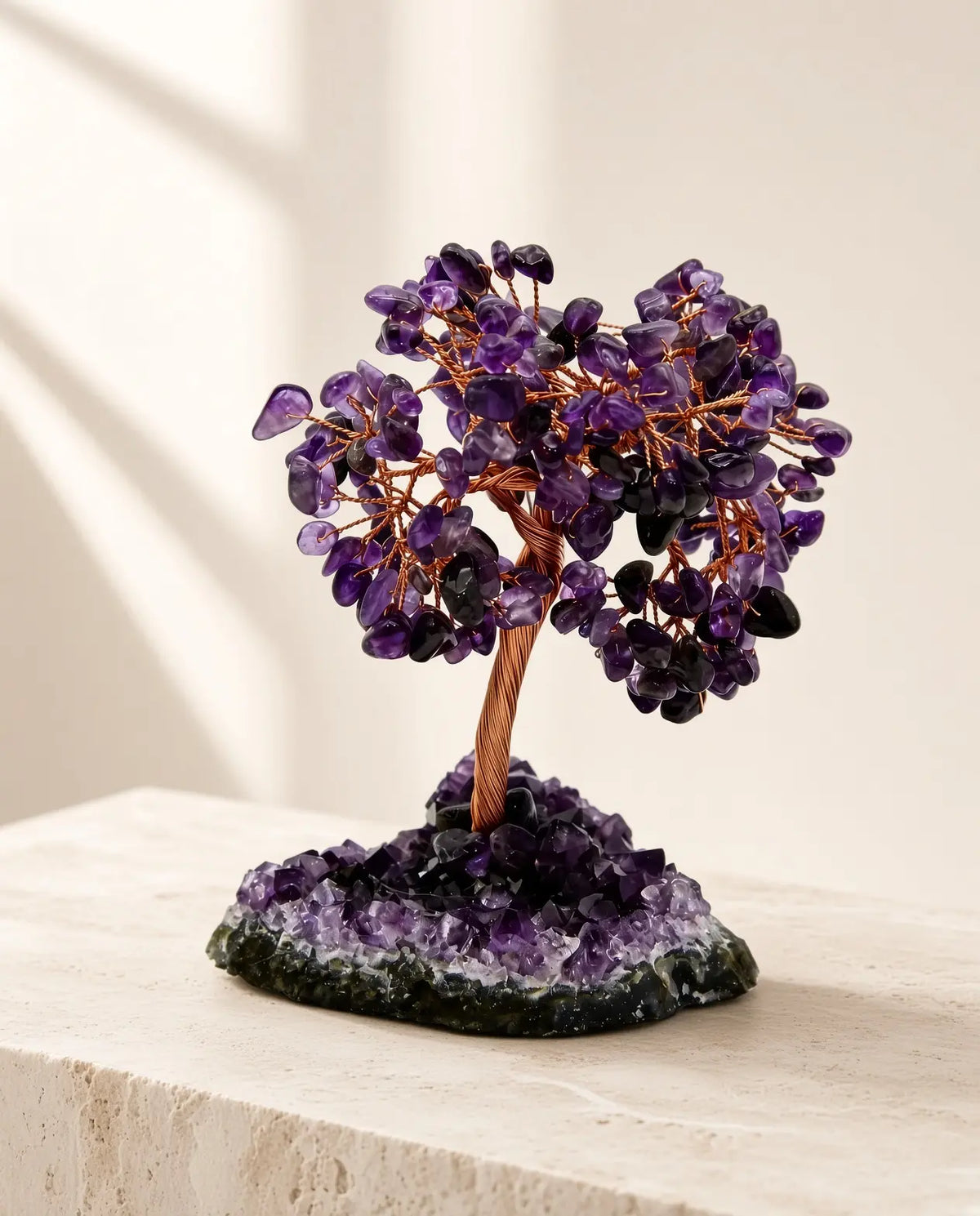 Amethyst crystal tree on geode base displayed on a stone table
