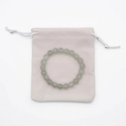 Natural moonstone beaded bracelet with translucent milky white 8mm round stones showing blue adularescence sheen, healing crystal jewelry for new beginnings on white background