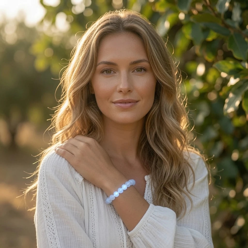 Close-up of natural moonstone bracelet beads showing distinctive adularescence light effect and milky translucent feldspar mineral texture with soft blue glow