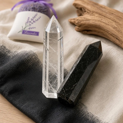 Clear quartz and black obsidian towers on black-and-cream linen with a lavender sachet and driftwood