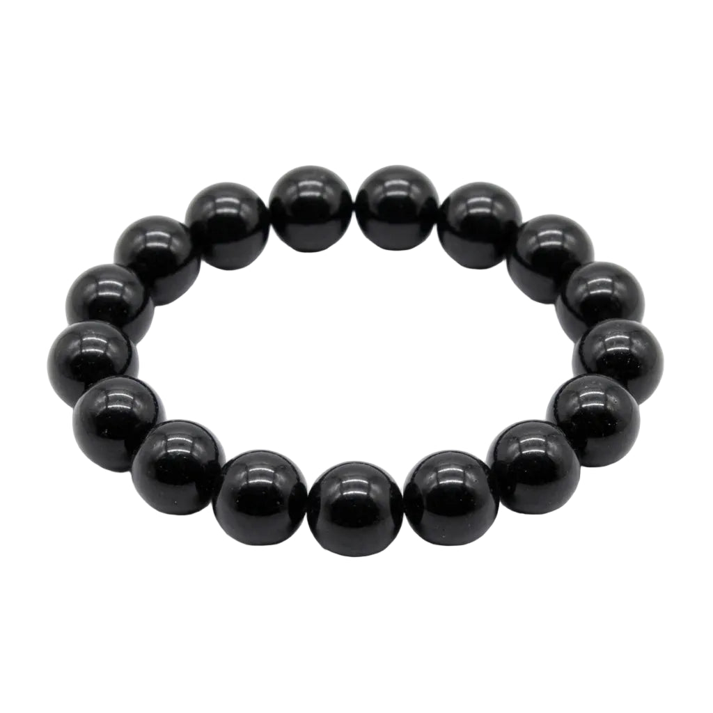 Natural black tourmaline polished bead bracelet with deep glossy 12mm round stones laid flat on white background, protection and grounding crystal jewelry
