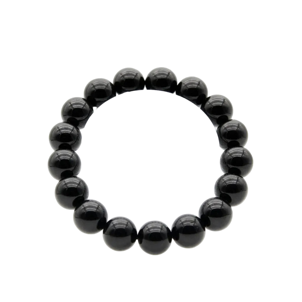 Natural black tourmaline polished bead bracelet with deep glossy 12mm round stones laid flat on white background, protection and grounding crystal jewelry