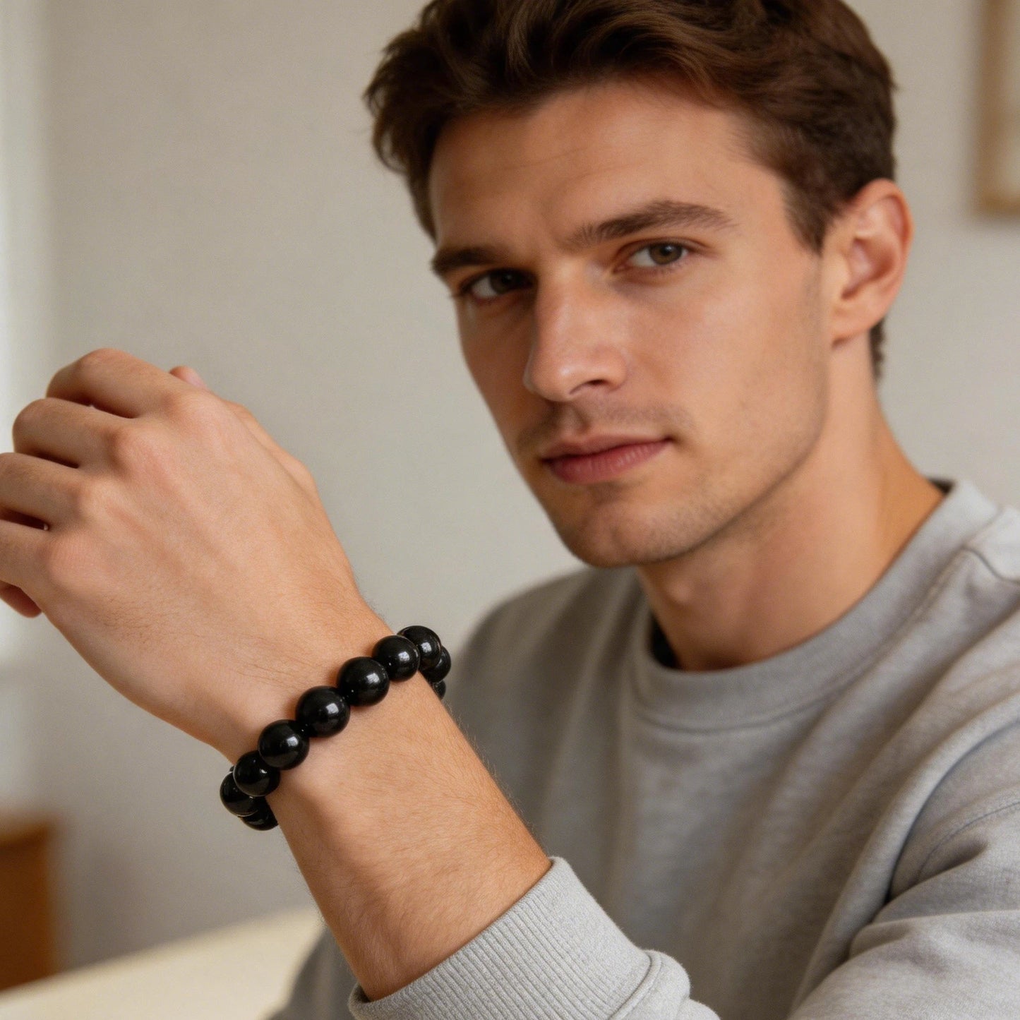 Close-up detail of natural black tourmaline bracelet showing high-polish deep black bead surface with natural mineral striations and vitreous luster