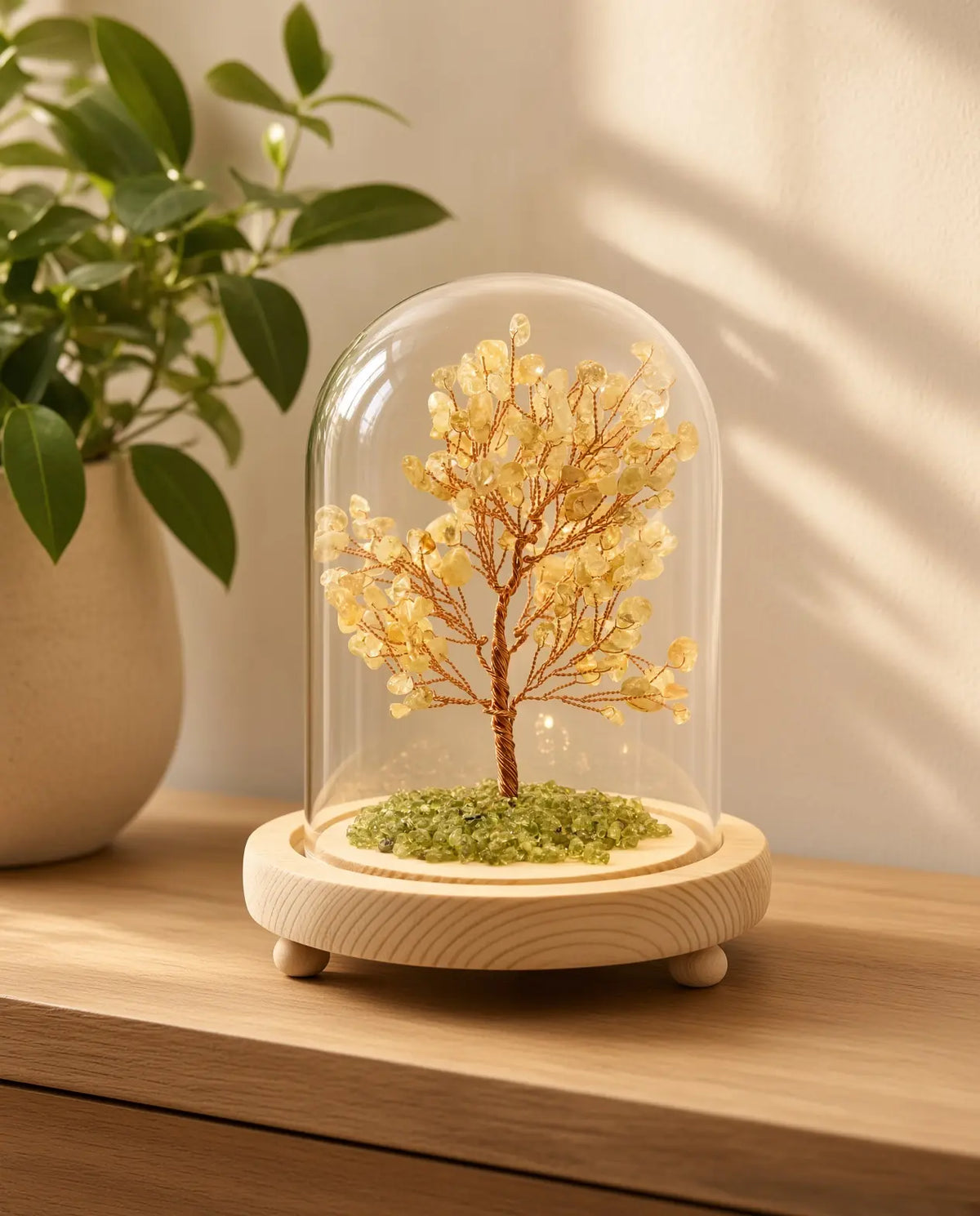 Citrine glow tree in a glass dome on a wooden table