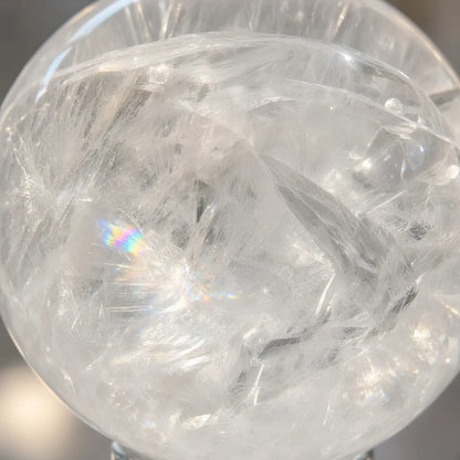 Close-up of clear quartz sphere with rainbow inclusions