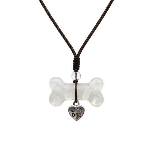 Natural clear quartz dog bone carved crystal pendant necklace with silver Love My Dog heart charm on adjustable brown braided cord, healing crystal jewelry for dog moms on white background