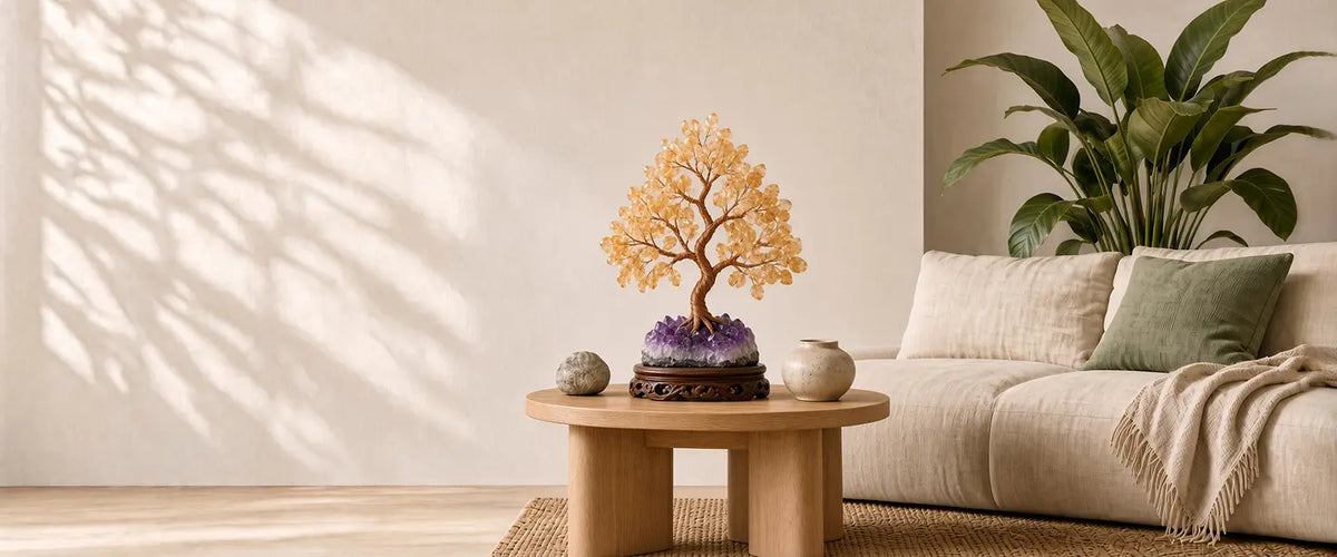 Citrine crystal tree on an amethyst cluster base, styled on a round oak coffee table in a sunlit living room with a linen sofa and large green plant