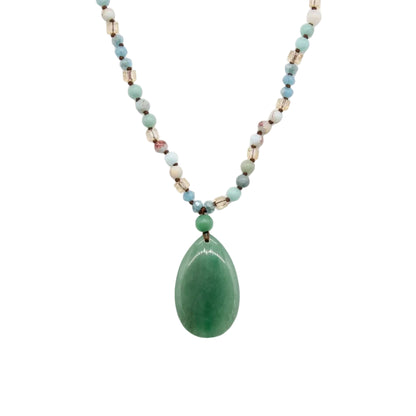 Green aventurine teardrop pendant on a beaded boho necklace, flat lay