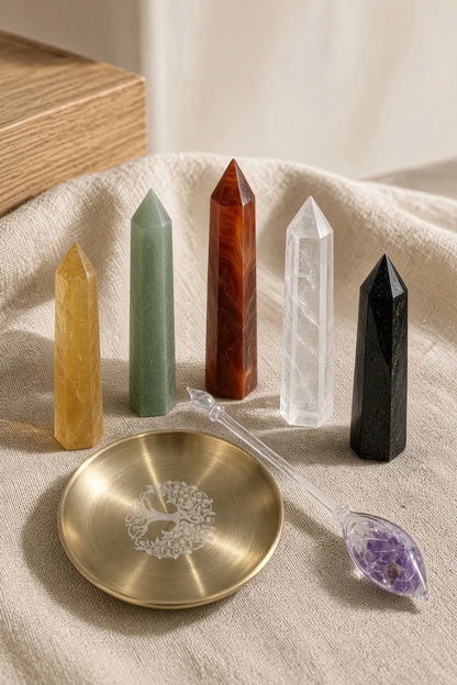 Five crystal towers on linen with a brass tree-of-life dish and a glass wand filled with amethyst chips