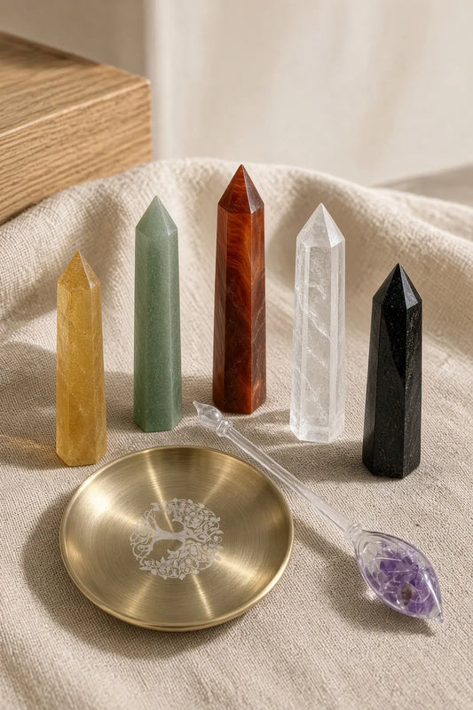 Five crystal towers on linen with a brass tree-of-life dish and a glass wand filled with amethyst chips