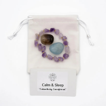 Amethyst bracelet and tumbled smoky quartz and aquamarine stones placed on nightstand beside candle for bedtime crystal ritual, healing crystals for sleep and relaxation