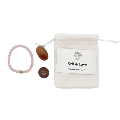 Self and Love healing crystal gift set with rose quartz beaded bracelet, tumbled carnelian, tumbled sunstone, affirmation card, and linen drawstring pouch on white background