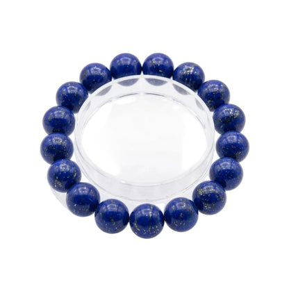 
Close-up detail of natural lapis lazuli bracelet beads showing deep blue lazurite color with golden pyrite mineral inclusions and white calcite veining
