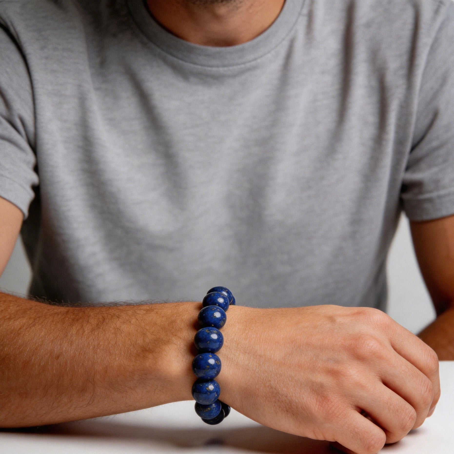 Lapis lazuli bracelet stacked with clear quartz and black tourmaline bracelets on wrist showing crystal healing layering style