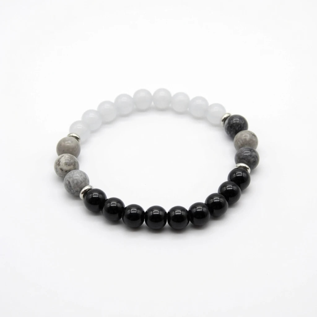 Moonstone, obsidian and gray stone beaded bracelet in black white and gray with silver spacers, flat lay