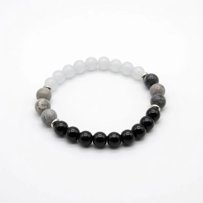 Moonstone, obsidian and gray stone beaded bracelet in black white and gray with silver spacers, flat lay