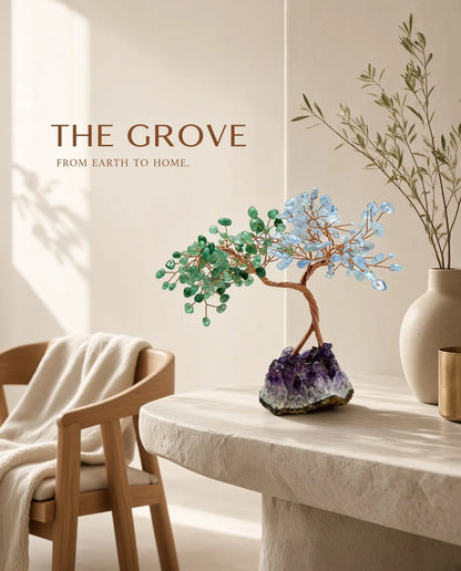 Rose quartz and aquamarine crystal tree on a stone ledge with “The Grove” brand text