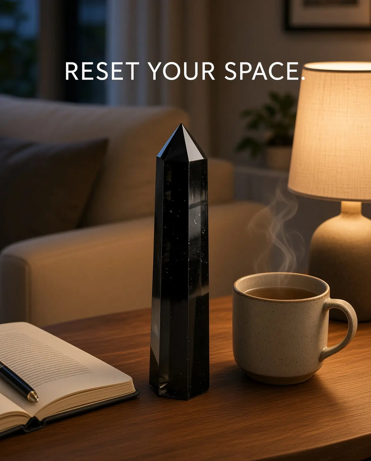 Obsidian crystal tower styled with tea, lamp and book in evening light