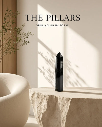 Obsidian crystal tower on a stone table with “The Pillars” brand text