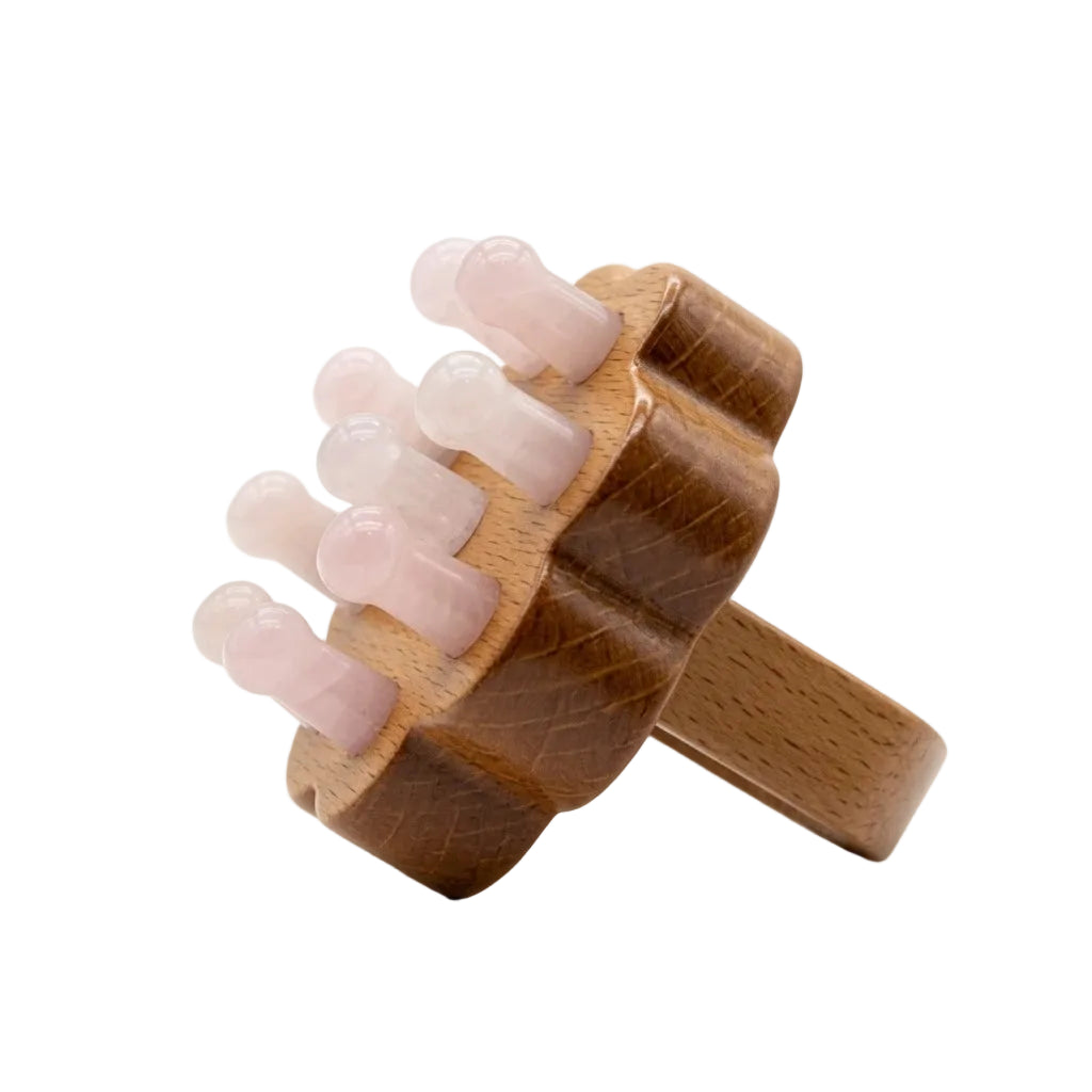 Natural rose quartz crystal bead scalp massager comb with beechwood handle, pink stone teeth on wooden base, beauty massage tool on white background