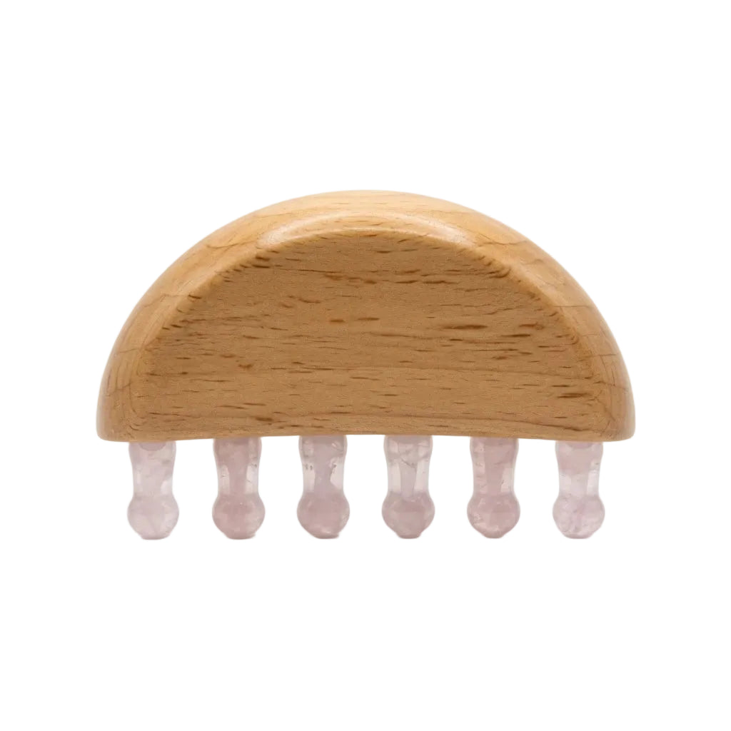 Natural rose quartz wide-tooth scalp gua sha comb with beechwood half-dome base and six pale pink crystal teeth, hair growth massage tool on white background