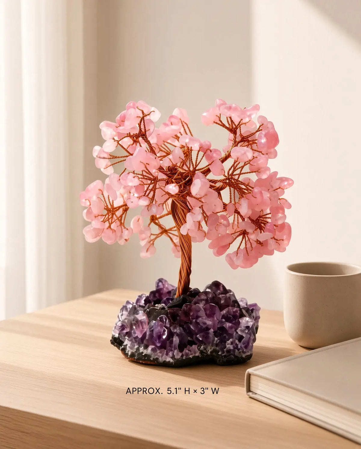 Rose quartz crystal tree on amethyst base, approx. 5.1" H × 3" W, displayed on a wooden table