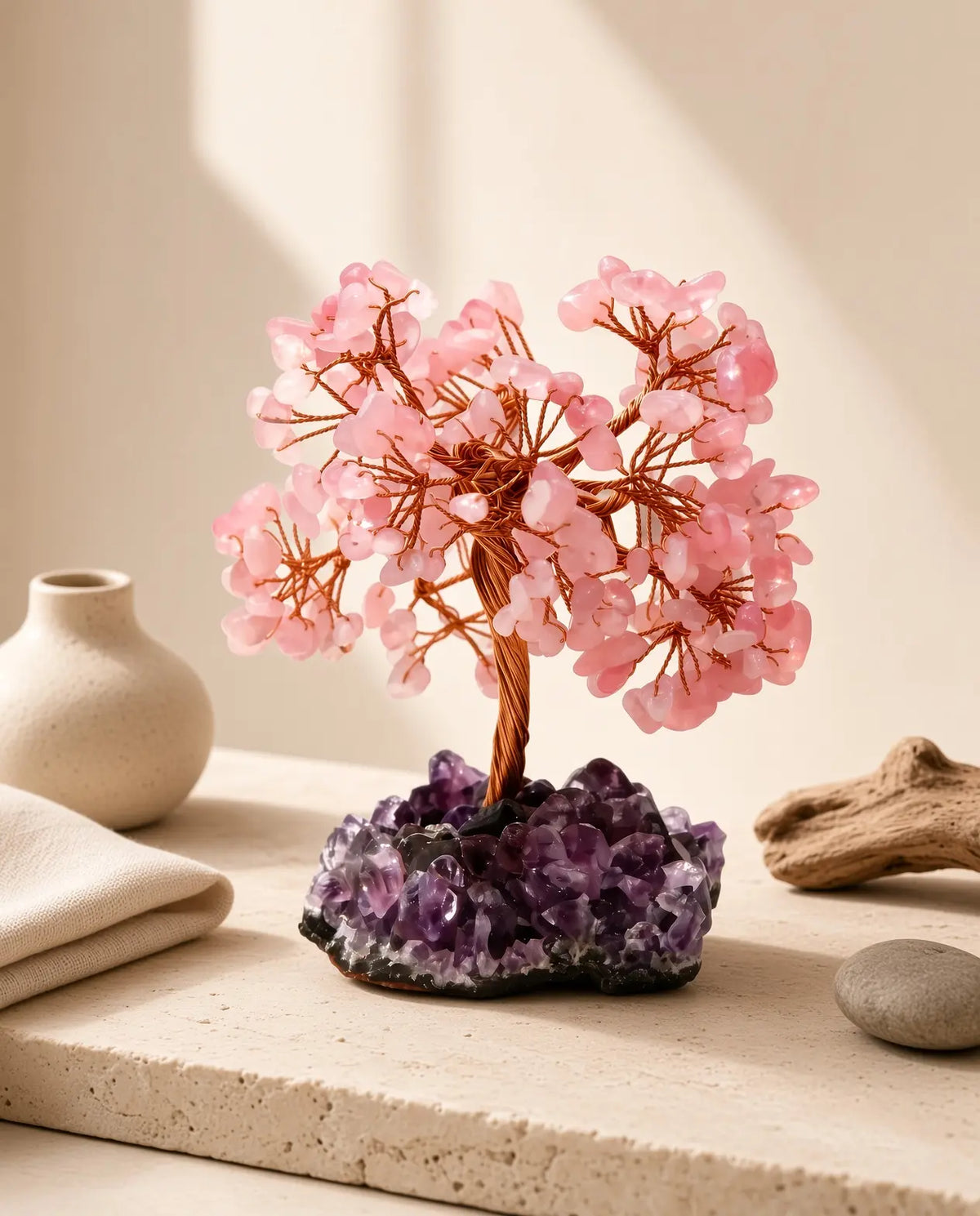 Rose quartz crystal tree on amethyst base styled with natural home decor in soft sunlight