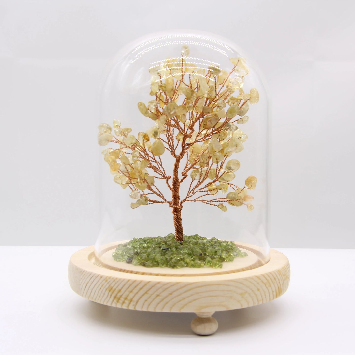 Citrine crystal tree of life lamp in glass dome, warm LED light on wooden nightstand, cozy bedroom decor for abundance.