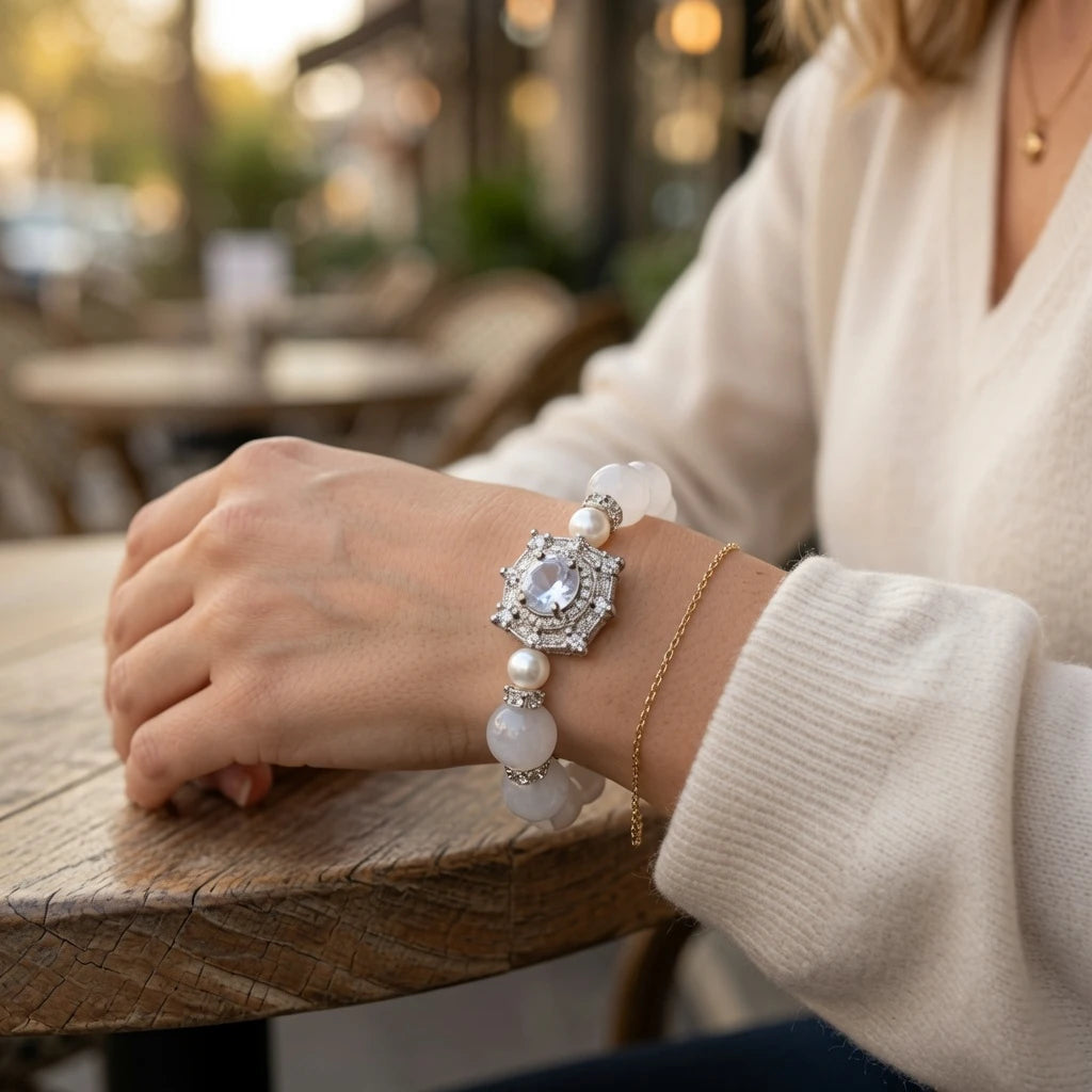 Woman wearing white jade crystal bracelet with CZ diamond rondelles and ornate silver centerpiece on wrist, luxury healing gemstone jewelry for crown chakra and emotional clarity