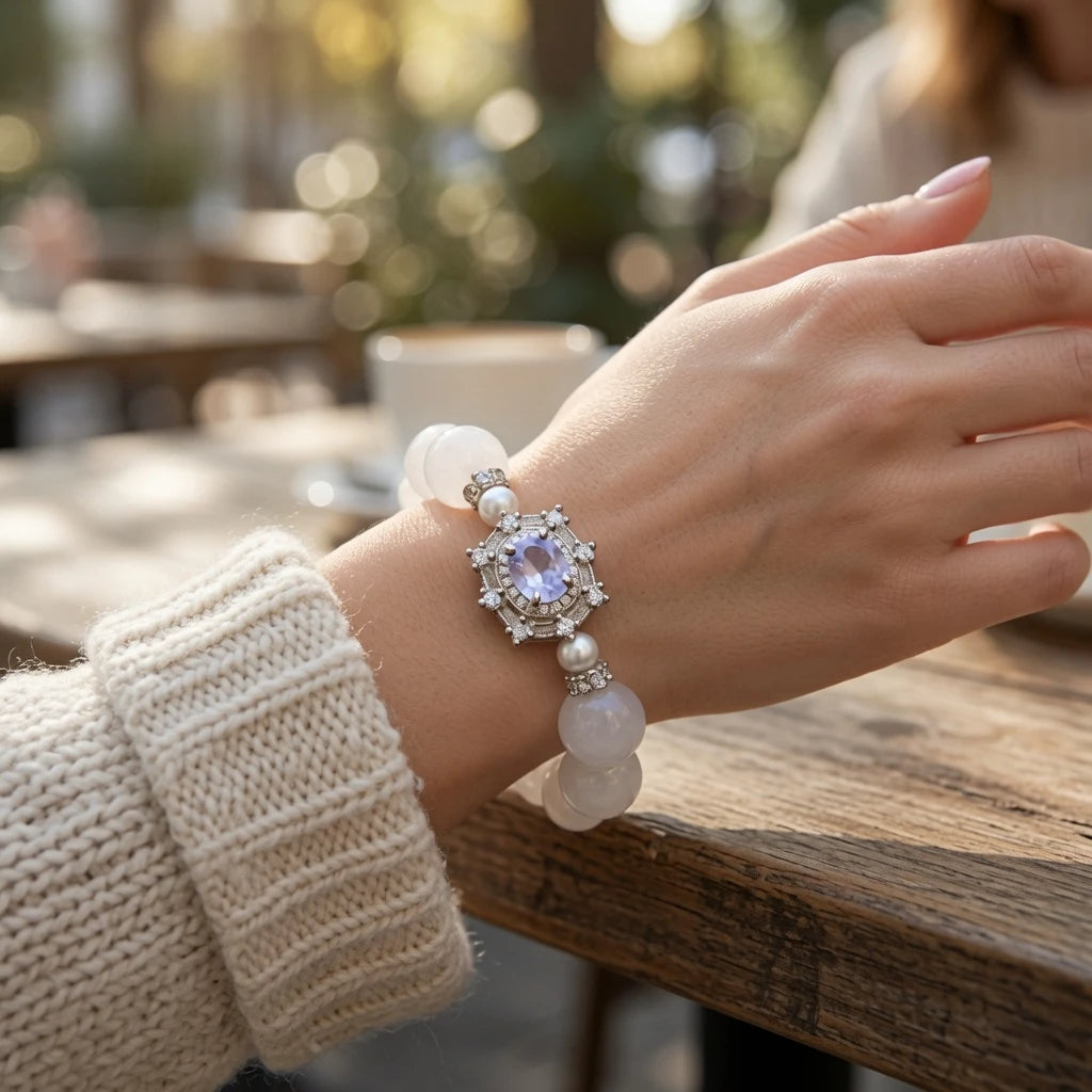 White jade crystal bracelet stacked with clear quartz and moonstone bracelets on wrist showing crown chakra crystal healing layering style for feminine elegant jewelry