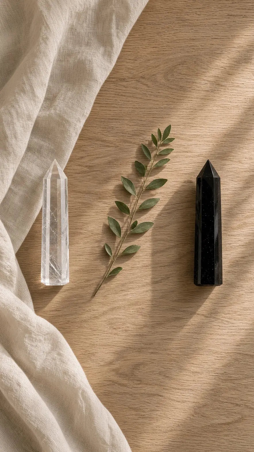 Clear quartz and black obsidian towers on a wooden table
