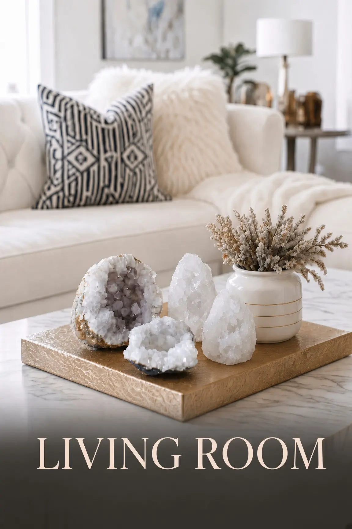 Modern living room scene featuring white crystal geodes on a gold tray in front of a white sofa